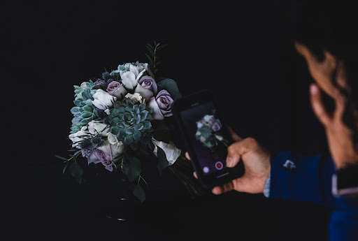 Mayuri Parikh, Florist, is Photographing her floral design arrangement indoors and taking videos to post on social media.